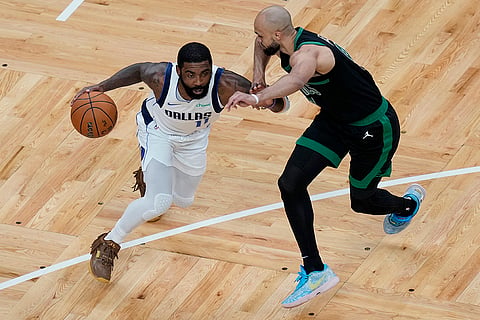 Kyrie Irving tries to drive past Derrick White